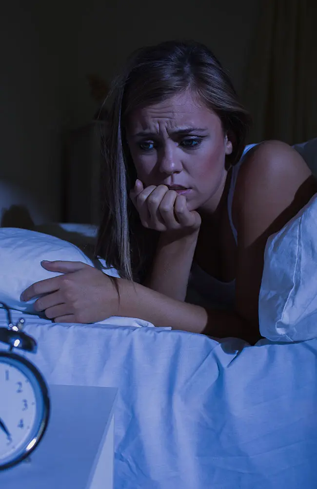 Mulher está acordada com insônia, tarde da noite