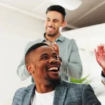 Colaboradores e gestores batem palmas para um moço que está sentado, refletindo a importância da NR-1 e felicidade corporativa